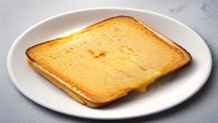 Top-down view of a golden grilled cheese sandwich cut into triangles.
